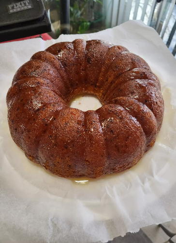 A freshly baked orange bundt cake with a glossy citrus glaze, showcasing its moist texture and vibrant flavor